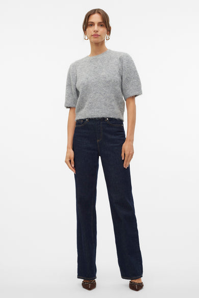 Grijze trui met ronde hals van VERO MODA, gecombineerd met donkere jeans en bruine schoenen.
