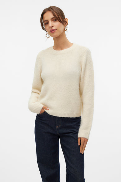 T-shirt écru avec col rond de VERO MODA, gros plan sur la ligne du col et boucles d'oreilles dorées.