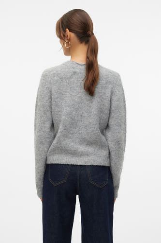 Grijze trui met ronde hals van VERO MODA, gezien van achteren, met donkerblauwe jeans en gouden oorbellen.
