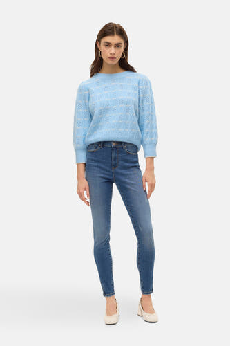 Blauwe trui met ronde hals van VERO MODA®, fijne breistructuur en lange mouwen, gecombineerd met een jeans.
