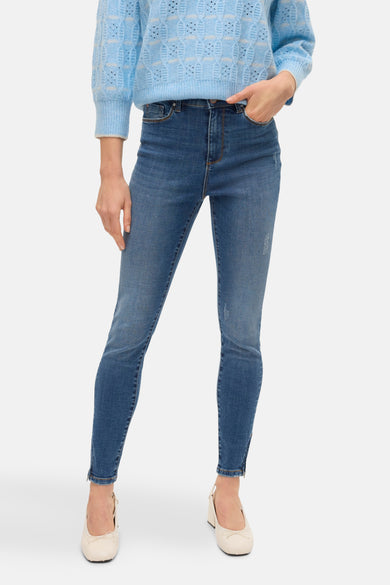 T-shirt bleu avec col rond de VERO MODA, porté avec un pantalon en cuir et des escarpins.