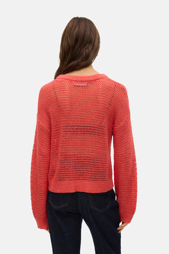 Chemise orange avec col rond de VERO MODA, à manches longues et ouvertes, associée à un pantalon de travail foncé.