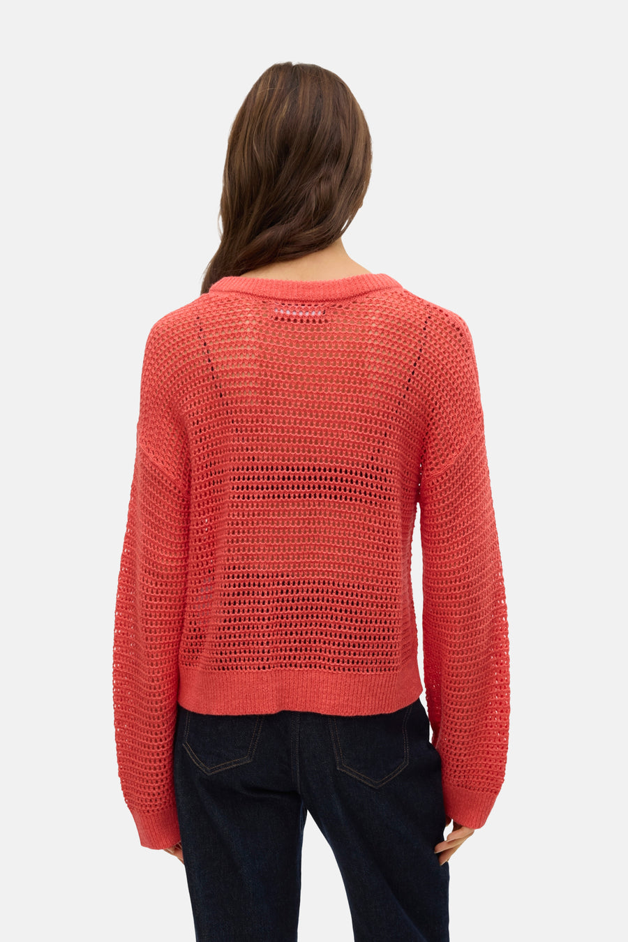 Chemise orange avec col rond de VERO MODA, à manches longues et ouvertes, associée à un pantalon de travail foncé.