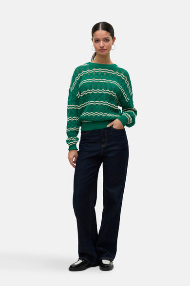 Groene trui met ronde hals van VERO MODA®, met decoratief golvend streepjespatroon en donkere jeans.
