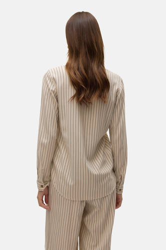 Chemise beige à manches longues de Vero Moda avec un fin motif rayé vertical sur un fond uni.