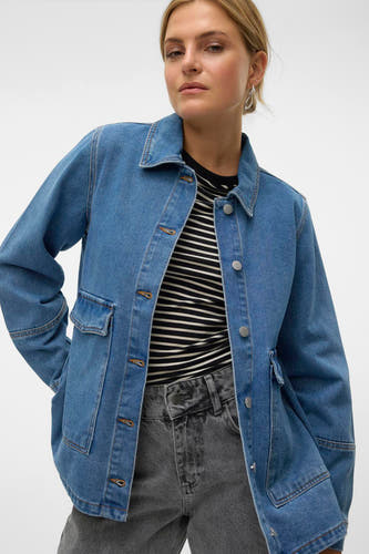 Jeansjas in medium blauw denim van VERO MODA, met opgestikte zakken en een gestreepte top eronder.

