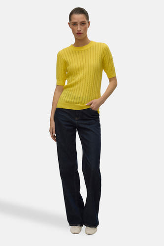 Gele trui met ronde hals van VERO MODA, gecombineerd met donkere jeans en witte ballerina's.