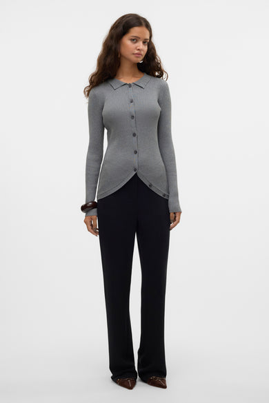 Grijze V-hals trui van VERO MODA®, gedragen met zwarte broek en bruine schoenen.