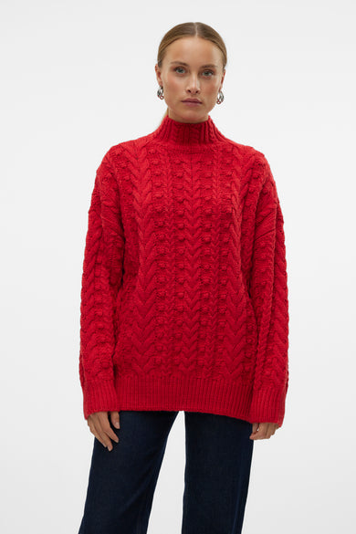 Pull-over rouge avec col rond de VERO MODA, à motif côtes et longues manches, associé à un jeans foncé.