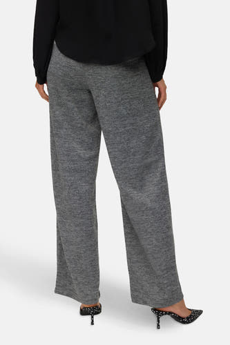 Grijze broek van VERO MODA, met een gemêleerde textuur, gecombineerd met een zwarte blouse en stiletto hakken met stippen.
