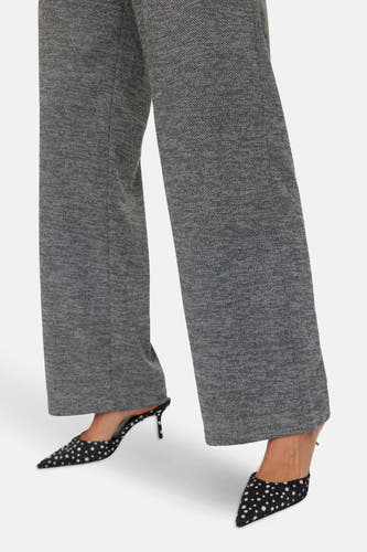 Grijze broek van VERO MODA, met een subtiele textuur, gecombineerd met zwart-witte stiletto pumps.
