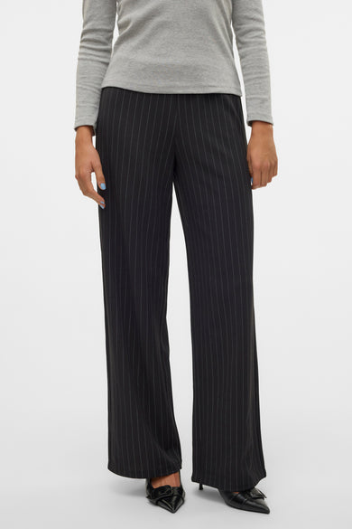 Zwarte broek van VERO MODA, met krijtstrepen en gecombineerd met een grijze top en zwarte schoenen.