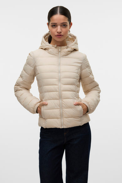 Ecru korte jas van Vero Moda met capuchon en lange mouwen, gedragen met donkere jeans.
