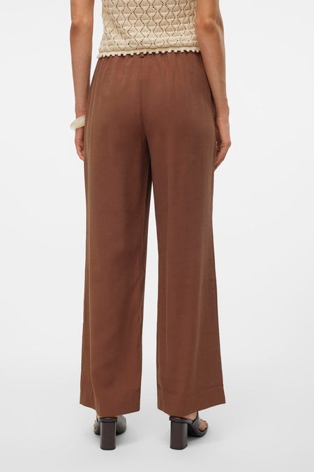 Bruine broek van VERO MODA, met wijde pijpen en een elastische tailleband, gezien van achteren.