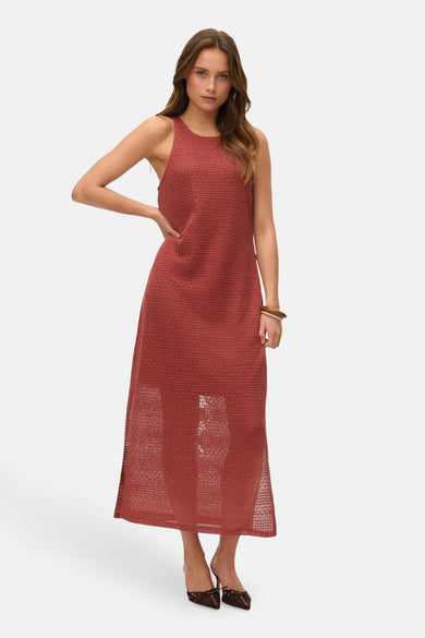 Rode, mouwloze jurk van VERO MODA, met een opengewerkte textuur en een houten armband.
