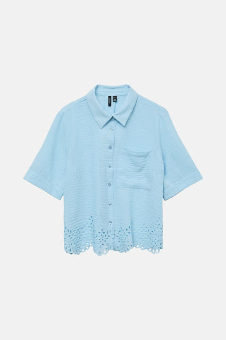 Chemise bleue claire à manches courtes de Vero Moda, avec poche devant et détails sur les bords en bas.