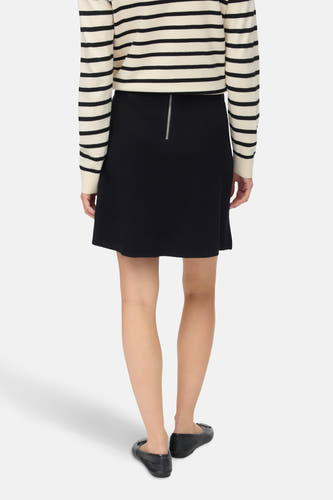 Zwarte korte rok van VERO MODA® met zilveren ritssluiting aan de achterkant, gedragen met een gestreepte trui.
