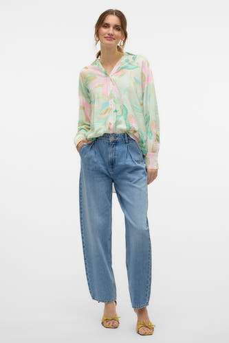Jeans special fit van blauw denim van VERO MODA, met plooien en gedragen met een blouse met print.
