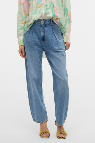 Jeans special fit van blauw denim van VERO MODA, met plooien aan de voorkant, gecombineerd met een bloes met print.
