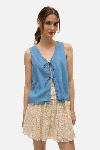 Blauwe blouse van VERO MODA, met strikdetail aan de voorzijde en gecombineerd met een kanten rok.