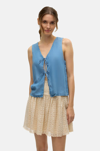 Blauwe blouse van VERO MODA met knoopdetail en een beige kanten rok.
