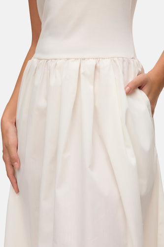 Ivoorwitte jurk met plooien en zakken.
