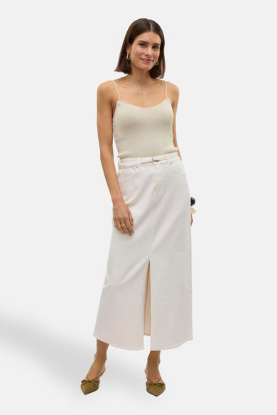Lange witte rok van VERO MODA, met split aan de voorkant, gecombineerd met een spaghettitop en lage hakken.
