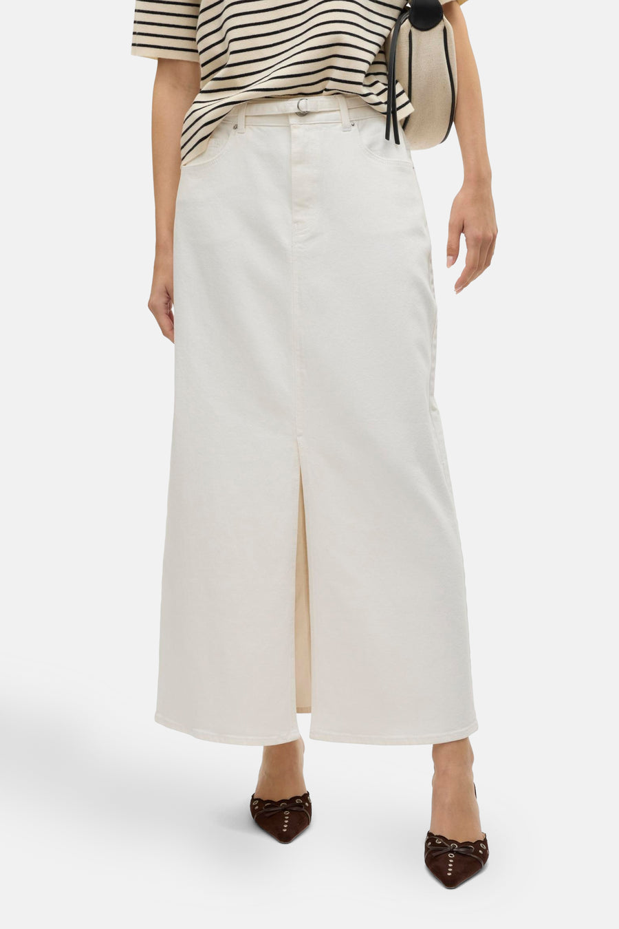 Robe longue blanche de VERO MODA, avec une fente à l'avant, associée à des chaussures brunes et un t-shirt rayé.
