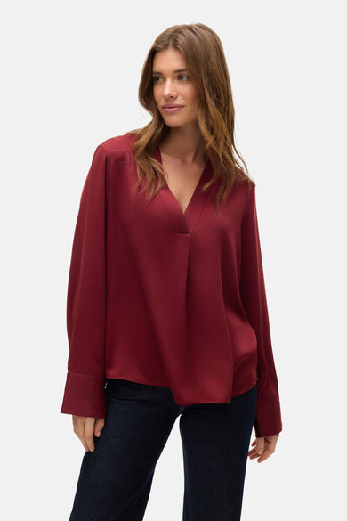 Rode blouse met lange mouwen van VERO MODA, gedragen met een donkere spijkerbroek.