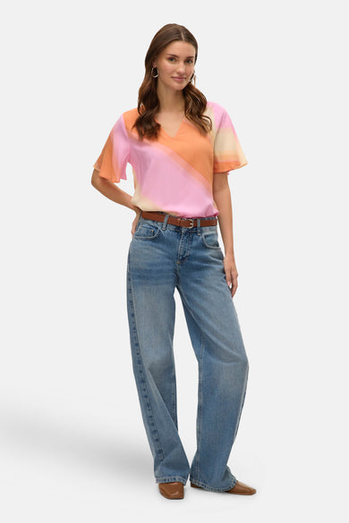 Multicolor blouse van VERO MODA, met een diagonale kleurverloop en gedragen met een bruine riem en blauwe jeans.