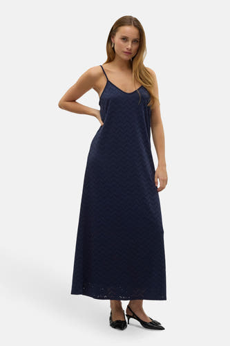 Donkerblauwe kleedje zonder mouwen van VERO MODA®, met een geperforeerd zigzagpatroon, gedragen met zwarte pumps.
