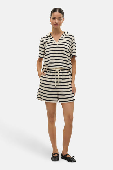Wit gestreept T-shirt met korte mouwen van VERO MODA®, met bijpassende shorts en zwarte schoenen.