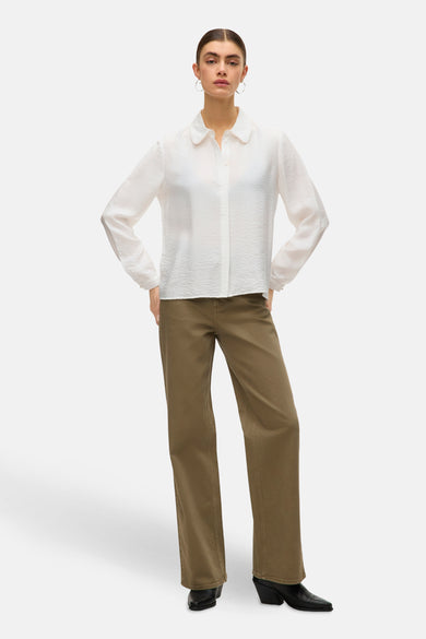 Wit, langarmig hemd van VERO MODA®, met kraag en zichtbare textuur, gecombineerd met een groene broek en laarzen.