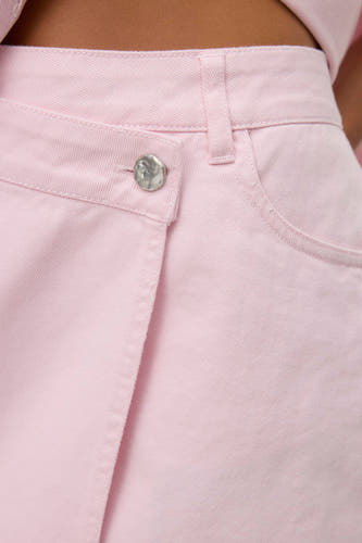 Roze korte rok van VERO MODA, met zilverkleurige knoop en subtiele stiksels.
