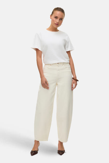 Jeans special fit van off white denim van Vero Moda, met wijde pijpen en bruine muiltjes.
