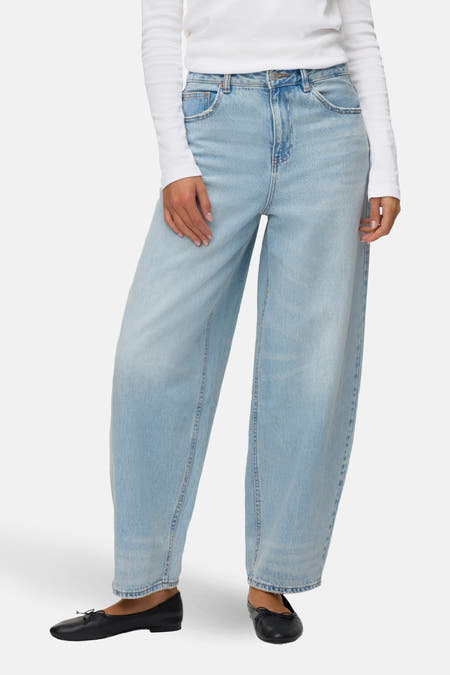 Lichtblauwe denim jeans van VERO MODA, met wijde pijpen en gecombineerd met een wit shirt en zwarte ballerina's.

