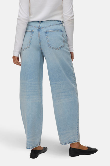 Lichtblauwe denim jeans van VERO MODA, gezien van achteren, met wijde pijpen en zwarte ballerina's.
