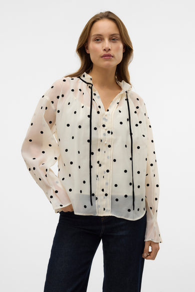Witte blouse met lange mouwen van VERO MODA®, voorzien van zwarte stippen en zwarte bandjes bij de hals.
