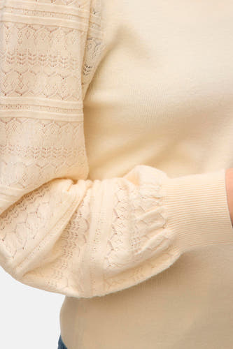 Sweat-shirt écru de Vero Moda avec col rond et détails ajourés sur les manches.