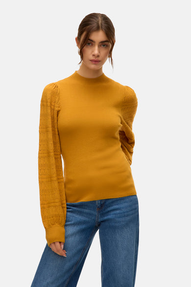 Pull bleu avec col rond de VERO MODA, man manues longues à motif ajouré et jeans bleus.