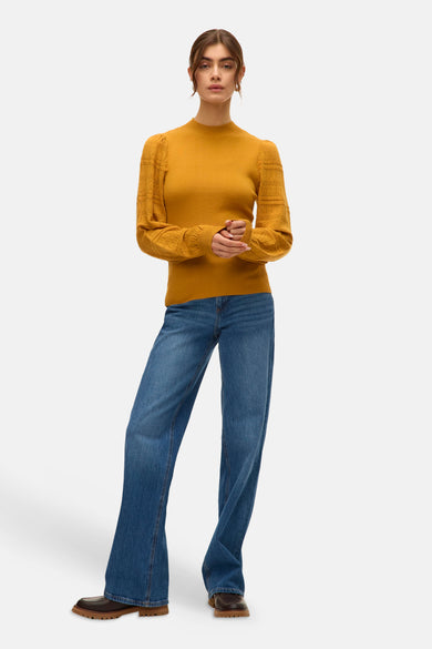 Sweat-shirt à col rond de VERO MODA® avec des manches longues et un fin motif rayé, associé à des jeans et des chaussures marrons.