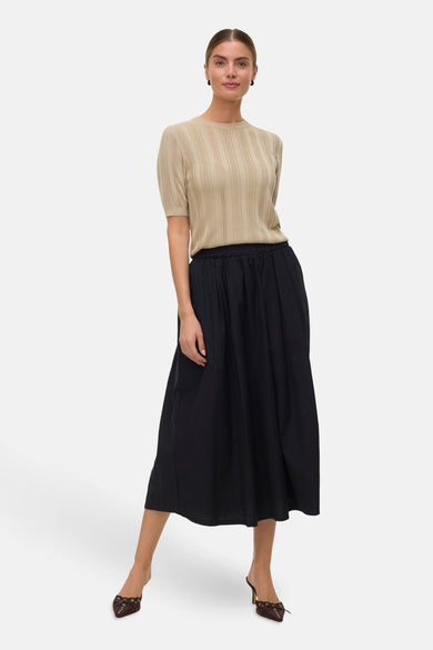 T-shirt vert avec col rond de VERO MODA, en fine maille et manches courtes, associé à une jupe noire.
