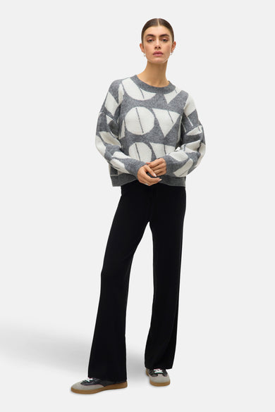 Sweat-shirt gris avec col rond de VERO MODA, à motif géométrique, associé à un short en côtes et et des sneakers.