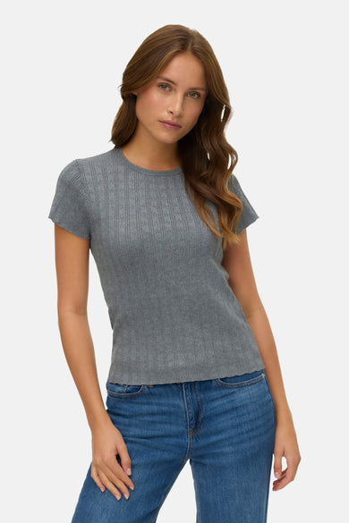 T-shirt gris à manches courtes de VERO MODA®, avec un motif structuré, porté avec un short en jeans bleu.