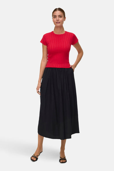 T-shirt rouge à manches courtes de VERO MODA, avec une subtile texture et porté avec une jupe noire.