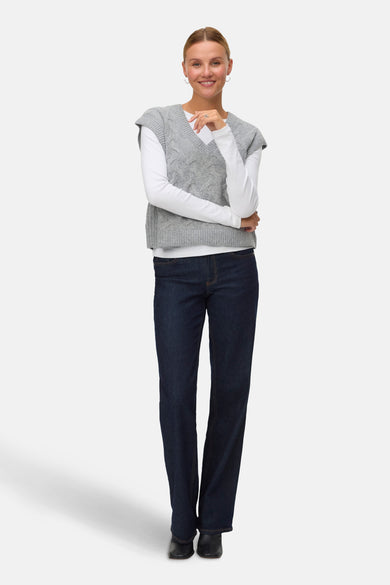 Gilet gris de VERO MODA, avec un motif côtelé, associé à une chemise blanche à manches longues et des jeans foncés.