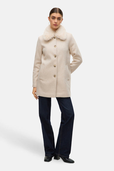 Mauve manteau court de Vero Moda, avec col en fourrure et fermeture à boutons, associé à des jeans foncés et des chaussures noires.