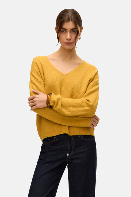 Pull à col V en vert de VERO MODA, associé à des jeans foncés et des chaussures marrons.