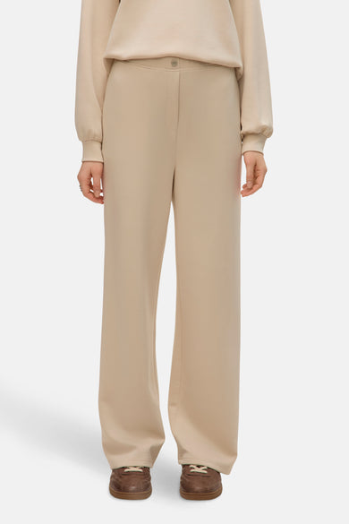 Ecru broek van VERO MODA, met een knoopsluiting en wijde pijpen, gecombineerd met bruine schoenen.
