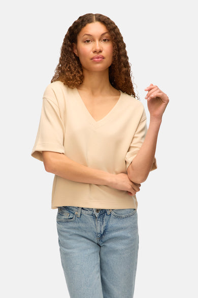 Ecru T-shirt met korte mouwen van VERO MODA, gecombineerd met een blauwe jeans.